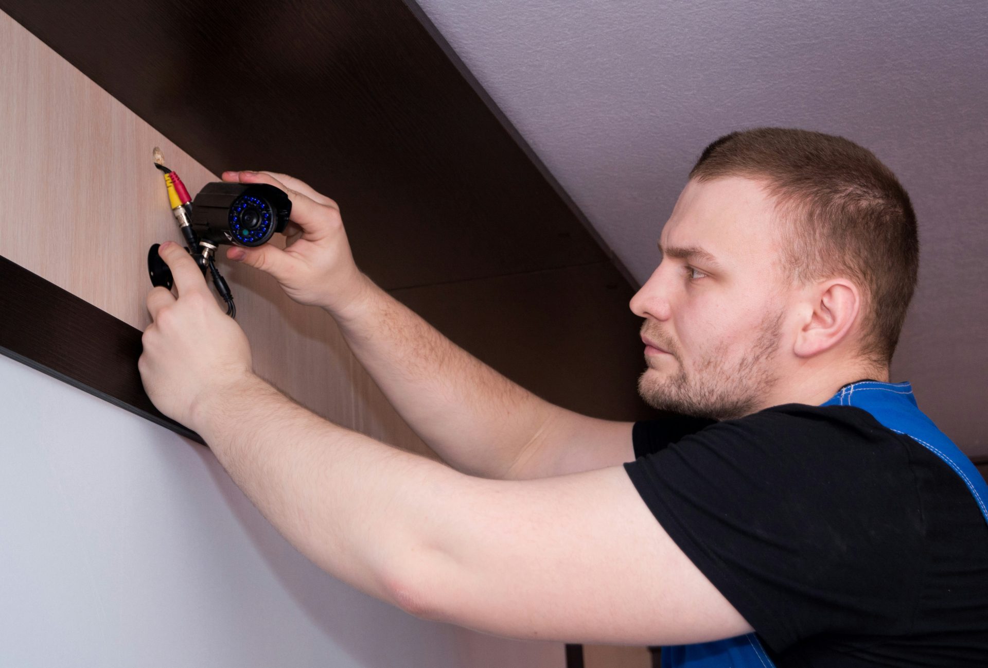 un homme travaillant sur un mur avec un tournevis